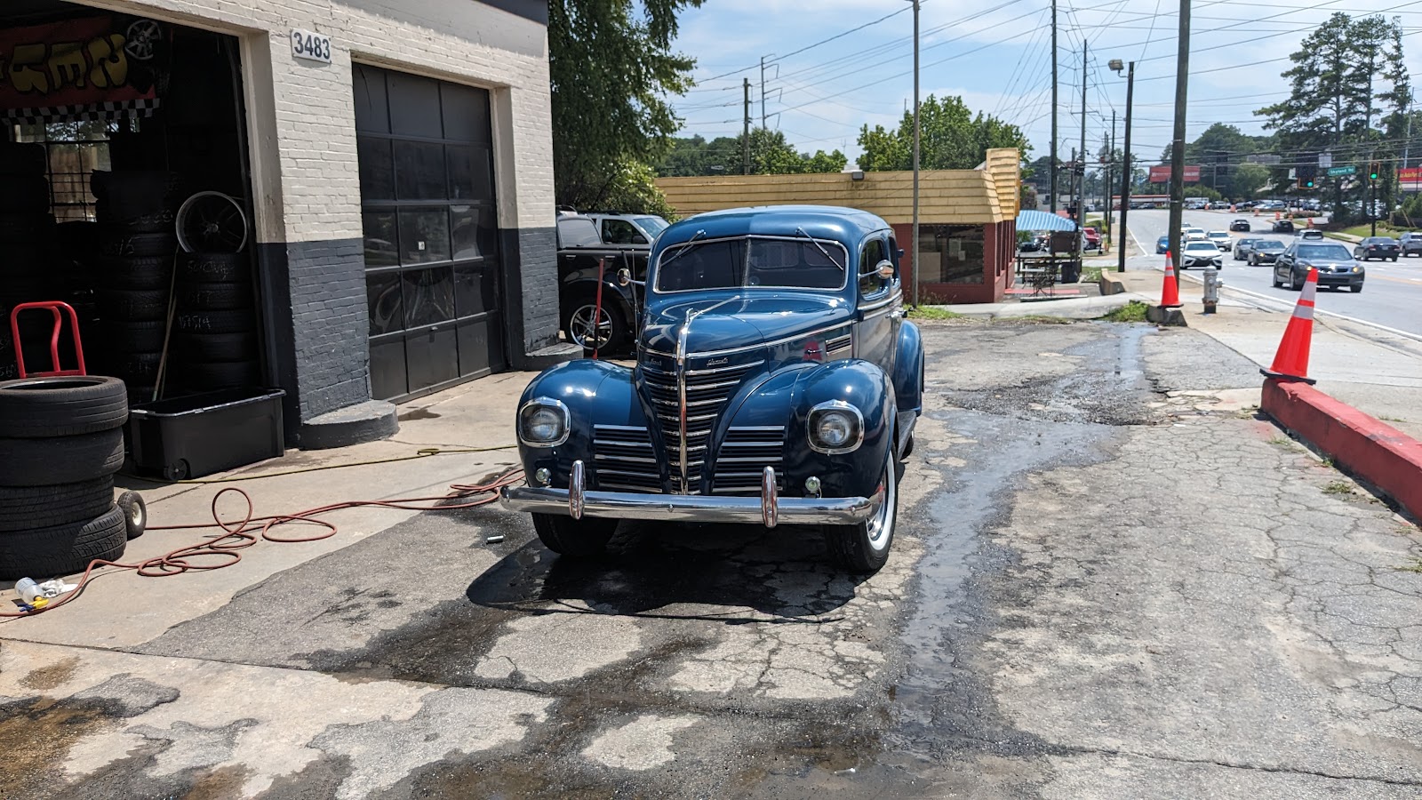 Piedmont Tires — vintage blue 1939 Plymouth sedan parked at the 3483 Clairmont service bay with an air hose running for tire service