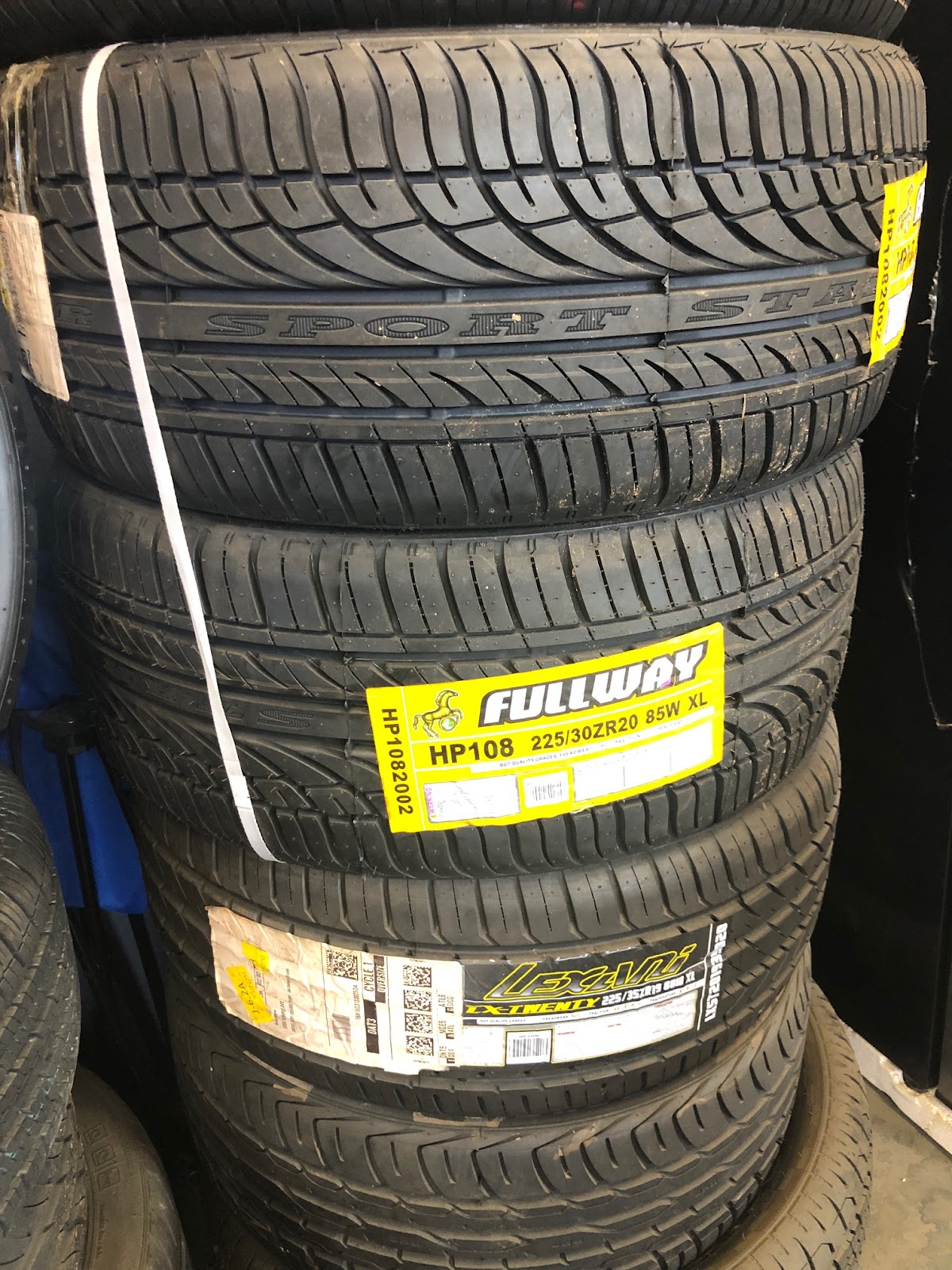 Piedmont Tires — four new Fullway HP108 performance tires stacked with price labels ready for install